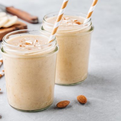 Healthy breakfast. Banana almond smoothie with cinnamon and oat flakes and coconut milk in glass jars